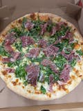 NY Style White Pizza - Topped with arugula and prosciutto.