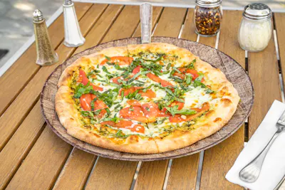 Pesto Pizza — fresh basil, pine nuts, Roma tomato, garlic, pesto, mozzarella and Parmesan